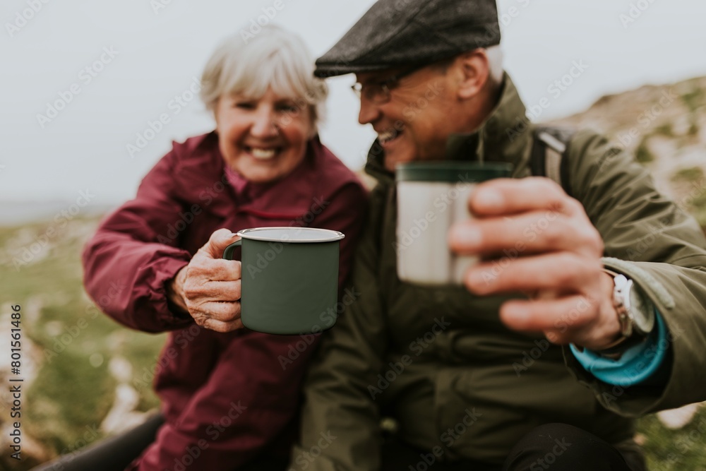 Fototapeta premium Happy senior couple drinking from mug, outdoor camping