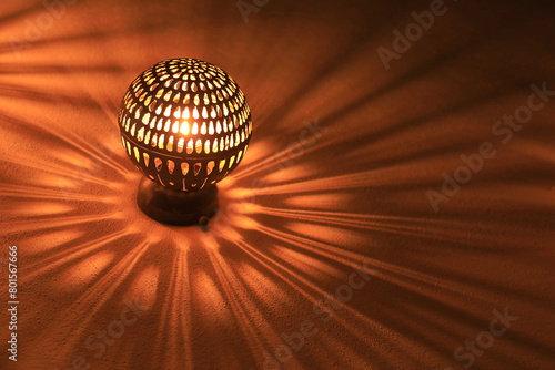 lámpara de pared metálica imitando a un sol haciendo sombras en forma de rayos y fuego 4M0A8185-as24