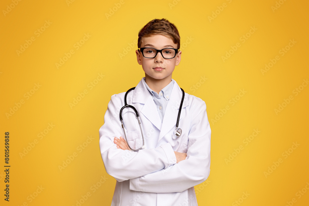 Handsome teenage doctor posing with arms crossed, orange panorama background with free space Handsome teenage doctor posing with arms crossed, orange panorama background with free space