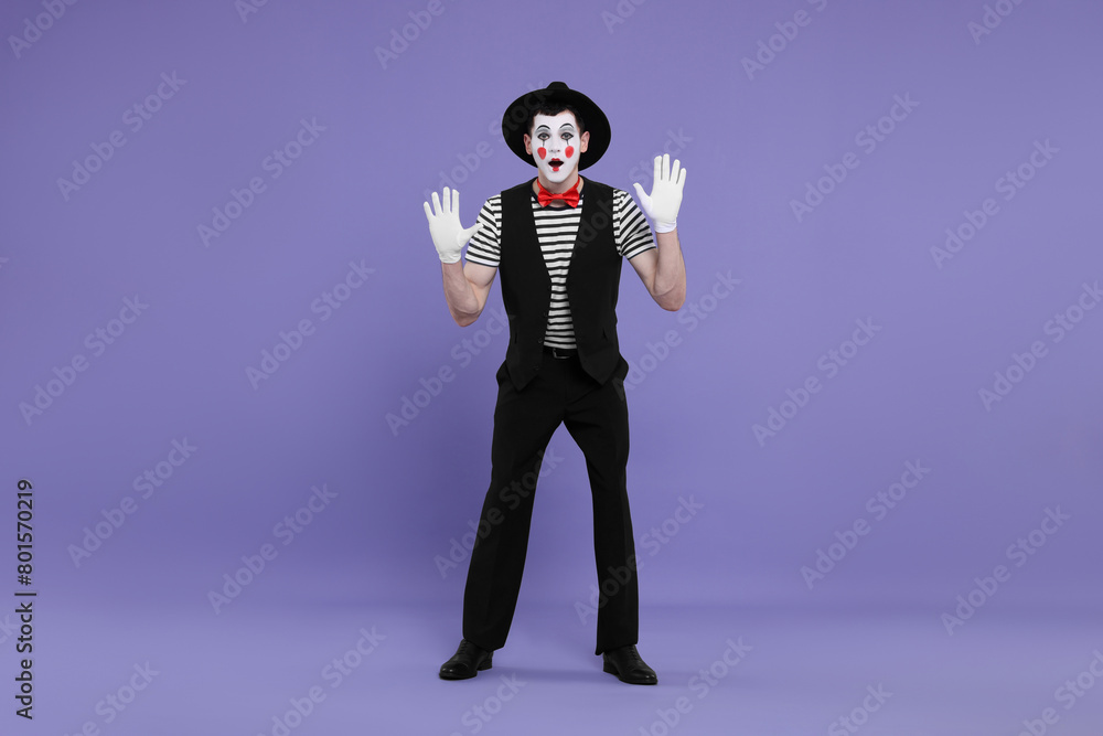 Mime artist making shocked face on purple background