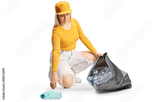 Young female collecting plastic bottles for recycling