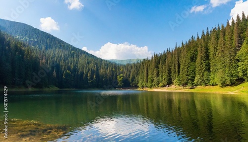 lake of synevyr national park in summer forested hills of carpathian mountains reflecting on the calm water surface sunny weather popular travel destination of ukraine