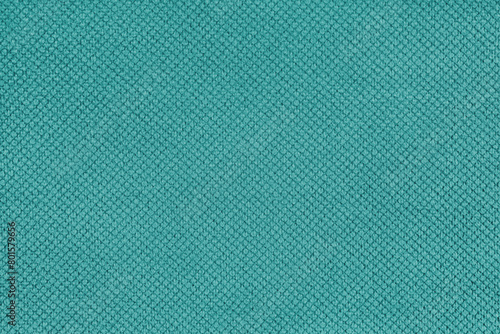 Plain turquoise velor upholstery fabric, jacquard with fine diamond texture background. Close up, macro cloth textile surface. Wallpaper, backdrop with copy space