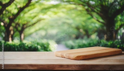 selective focus end grain wood counter top with cutting board on blur greeny tree garden in morning background for montage product display photo