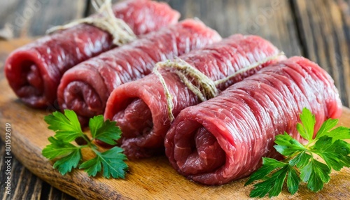 fresh raw beef roulades on wooden table photo