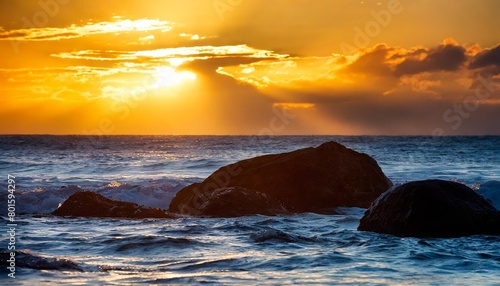 dramatic scene with big rocks sea sunbeam and sundown