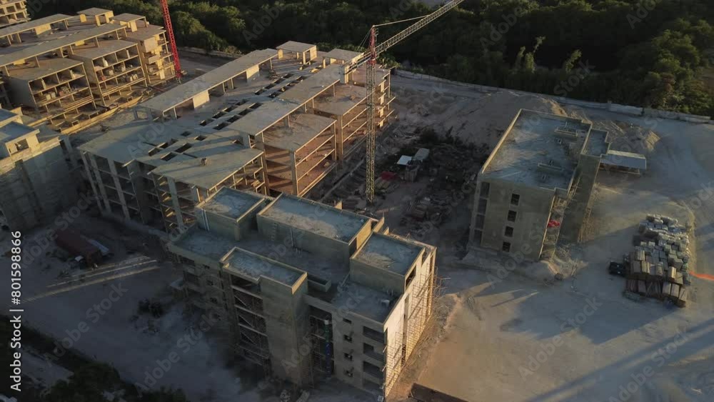 Drone view of large construction site for one more new hotel complex with large panoramic on Sunset located along seashore in Punta Cana, Dominican Republic. Noval. Tower crane, excavator and sand. Drone view of large construction site for one more new hotel complex with large panoramic on Sunset located along seashore in Punta Cana, Dominican Republic. Noval. Tower crane, excavator and sand.