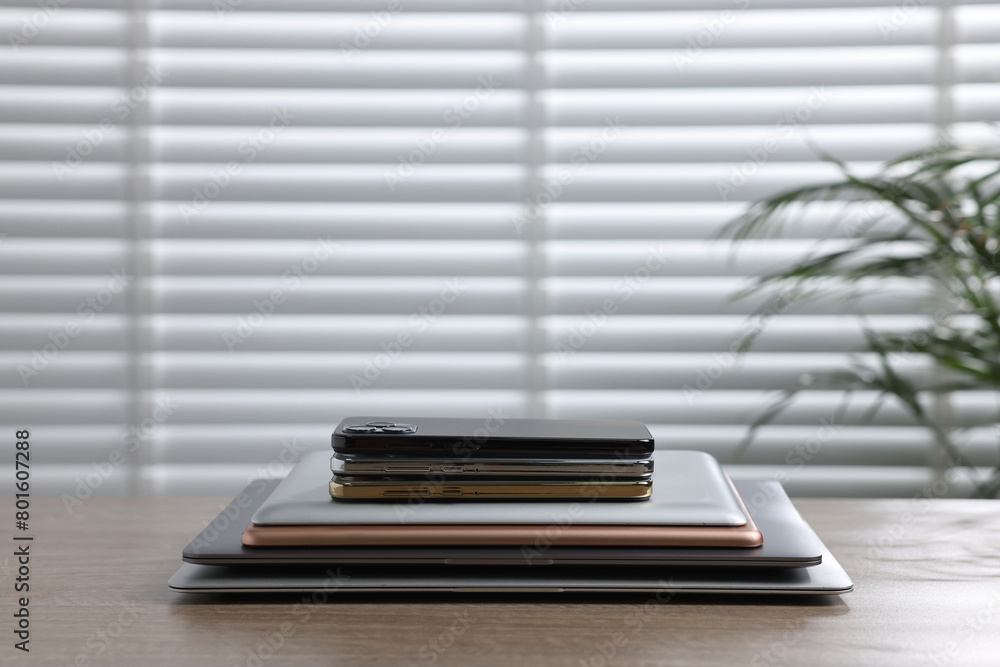 Many different modern gadgets on wooden table indoors. Space for text Many different modern gadgets on wooden table indoors. Space for text