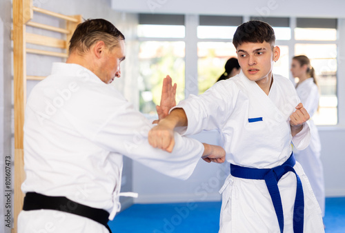 Athletes sparring during karate classes in the gym