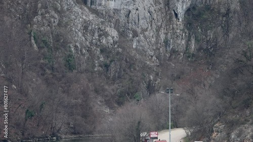 Rock Sculpture of Decebalus Last King of Dacia Colossal Face Carving in Stone at Danube River Gorge Tilt up Dubova Romania photo