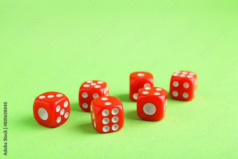 Many red game dices on green background, closeup Many red game dices on green background, closeup
