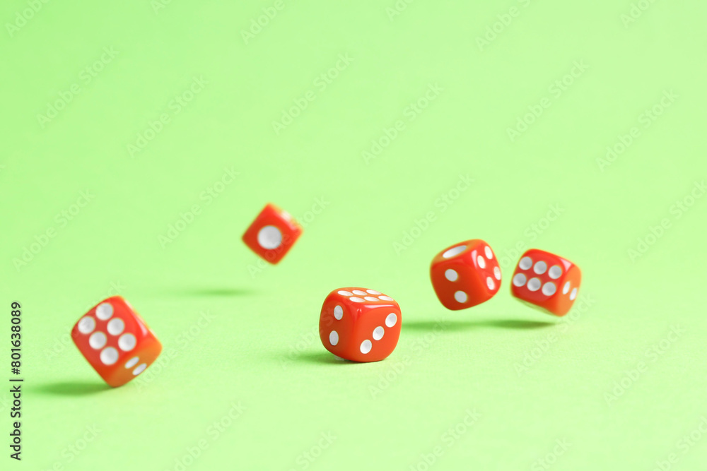 Many red game dices falling on green background Many red game dices falling on green background