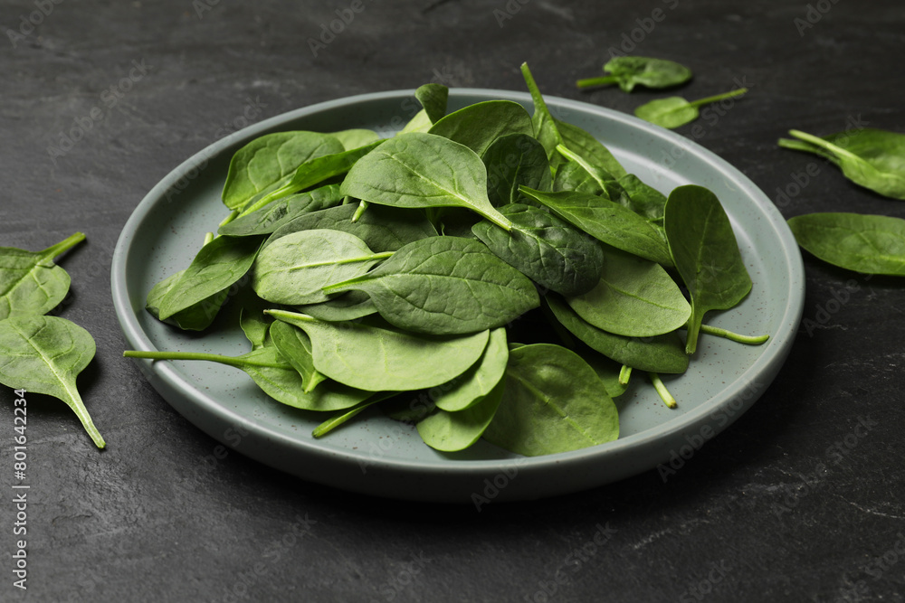 Fresh spinach leaves on dark textured table, closeup Fresh spinach leaves on dark textured table, closeup