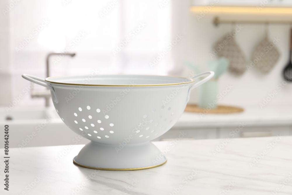 Clean colander on white marble table in kitchen. Space for text Clean colander on white marble table in kitchen. Space for text