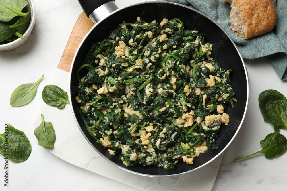 Tasty spinach dip with eggs in dish served on white table, flat lay