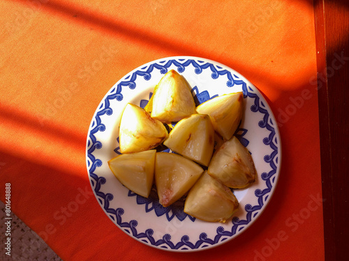 Abiu fruit cut into pieces on white porcelain plate with blue details photo