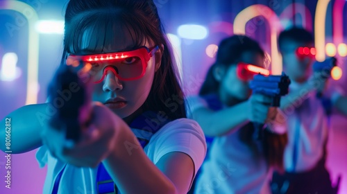 Two children are engaged in an intense laser tag battle, wearing high-tech visors and wielding laser guns amidst a vibrant, neon-lit gaming arena with a sci-fi ambiance photo
