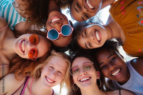 group of young people looking down at camera smiling together during summer time © Wirestock