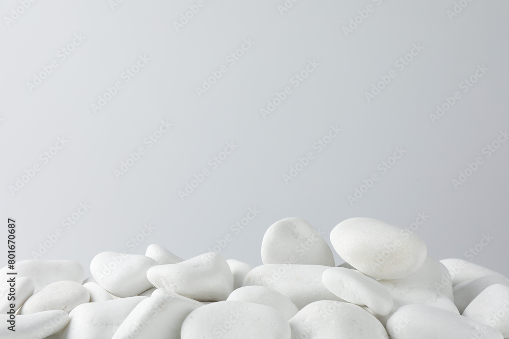 Presentation for product. White pebbles on light background. Space for text Presentation for product. White pebbles on light background. Space for text