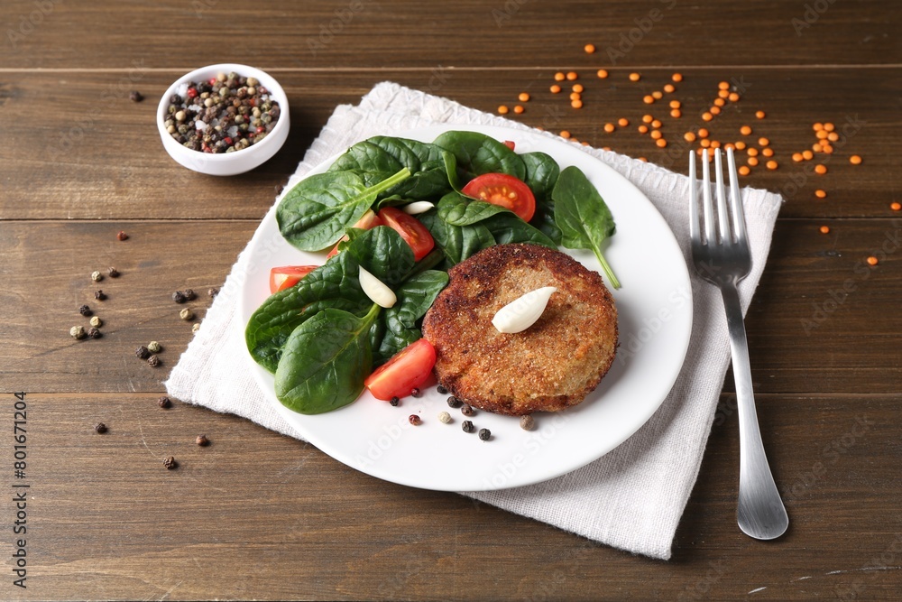 Tasty vegetarian cutlet served with vegetables on wooden table Tasty vegetarian cutlet served with vegetables on wooden table