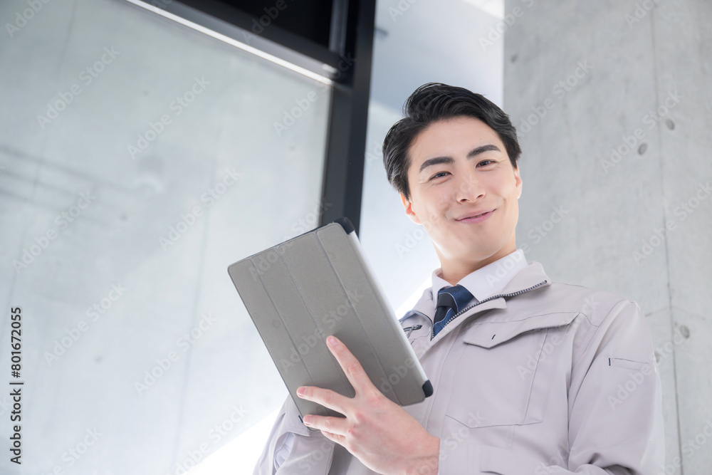 タブレットを持って笑顔の作業員ビジネスマン メンテナンスや施工管理などのイメージ カメラ目線 DXやIT化 タブレットを持って笑顔の作業員ビジネスマン メンテナンスや施工管理などのイメージ カメラ目線 DXやIT化