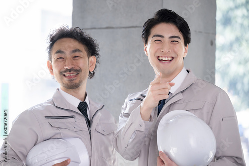 Two handsome workers with helmets Image of building construction management and maintenance inspection