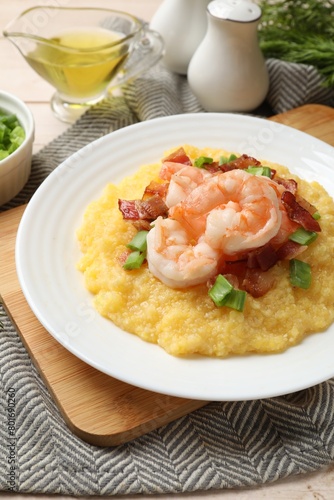 Plate with fresh tasty shrimps, bacon, grits and green onion on table, closeup