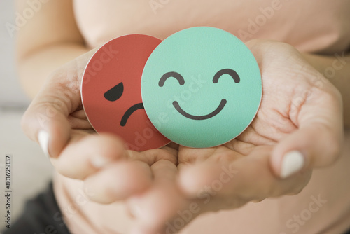 Middle age woman hands holding sad face hiding behind happy face, bipolar and depression, mental health, midlife crisis concept