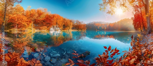 Panorama landscape of a lake surrounded by fiery autumn foliage at noon