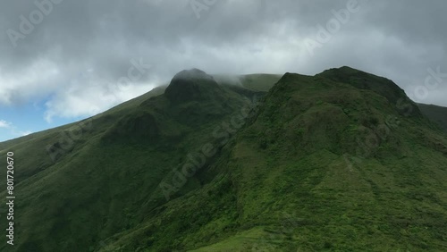 Aerial view. The camera moves near the caldera of the Mont Pele volcano in Martinique. Heavy low gray clouds float over the mountain. The amazing nature of the landscapes of the Caribbean islands.