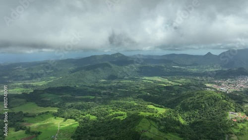 A beautiful aerial view of a picturesque valley on the Caribbean island of Martinique. Heavy low clouds float over the verdant landscape.