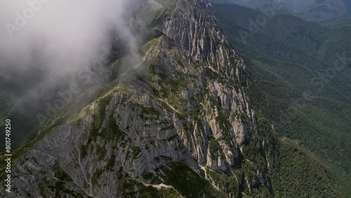 Clouds swirling around the peaks of piatra craiului mountains, aerial view photo