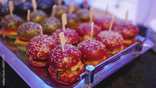 Burger mini burgers, snacks on a wooden table with craft paper, beautifully decorated catering banquet table on corporate christmas birthday party event or wedding celebration with colored burgers photo