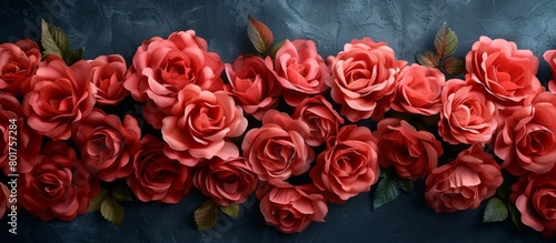 Vibrant red roses clustered together in a close-up view against a solid blue backdrop, creating a striking contrast
