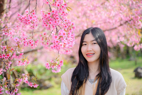 happy tourist asain woman in cherry blossom or sakura blooming in natural park Path through a beautiful country road 