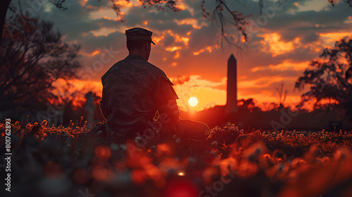 A soldier in contemplation at sunset, with a dramatic sky and silhouette of the Washington Monument in the background, symbolizing peace and remembrance.