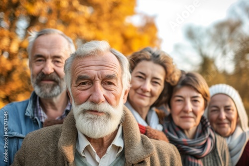Portrait of a happy senior couple with their family in autumn park