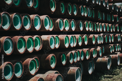 Piles of drilling pipes or casing in oil and gas open field storage . photo