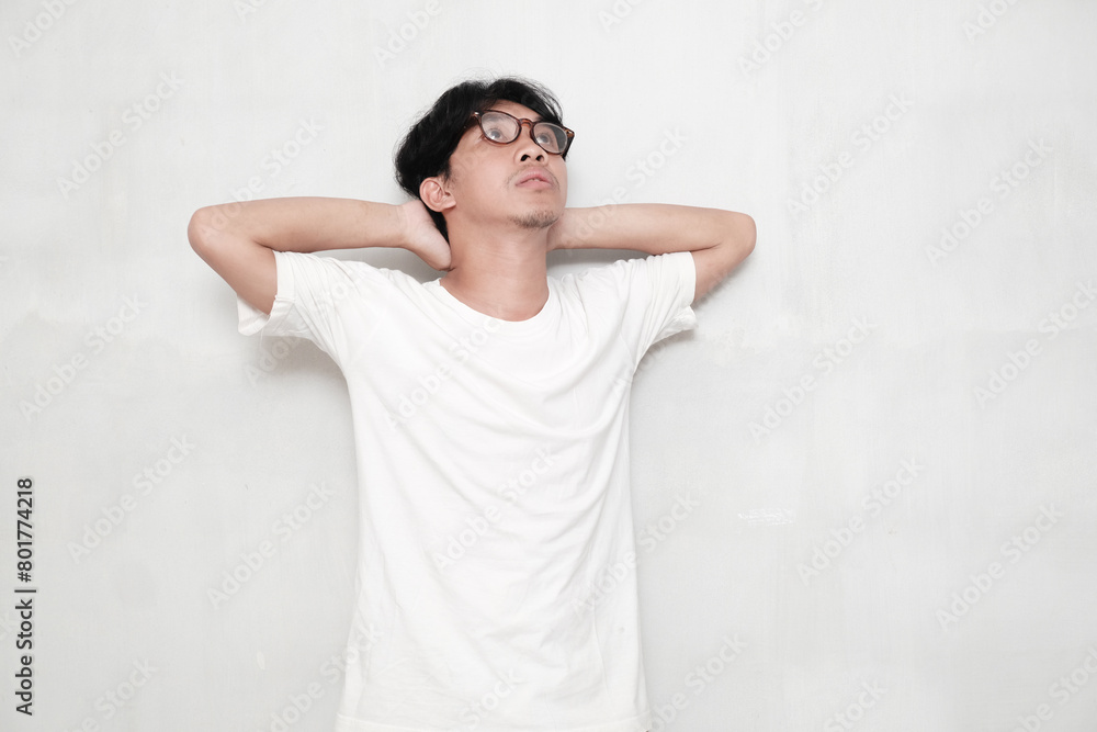 Asian man showing thinking gesture with his eyes looking up