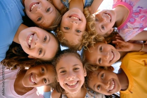 Top view of group of smiling kids looking at camera in a circle