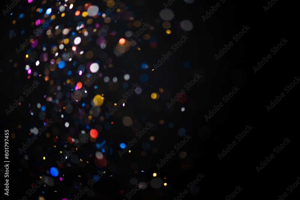 Colorful falling glitter sequin confetti on black background