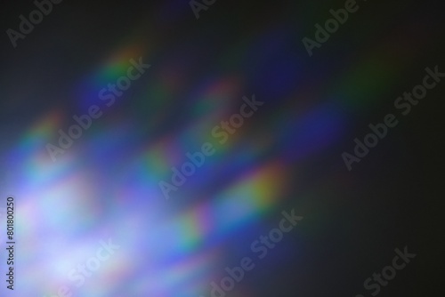 Iridescent rainbow blue prism light flare on black background