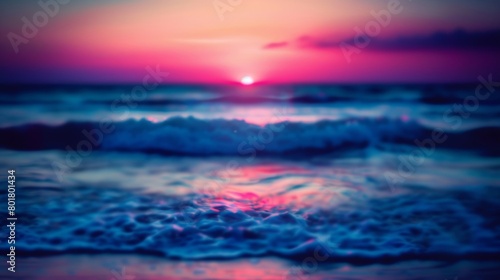 Blurry image of ocean waves under a sunset sky, with vibrant colors. © red_orange_stock