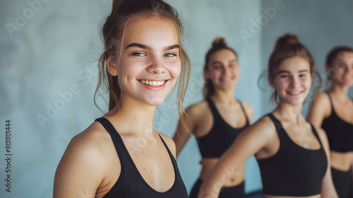 Happy young female athletes in a gym  smiling and standing in a row.