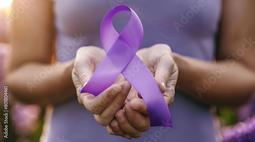 Hand holding purple ribbon, concern for people with lupus disease photo