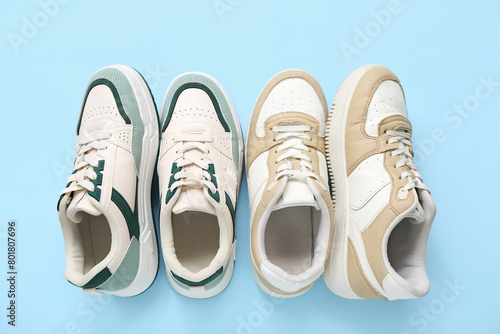 Different stylish sneakers on blue background