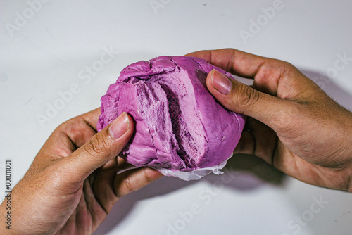 purple buns with blueberry flavor served with two hands tearing them apart