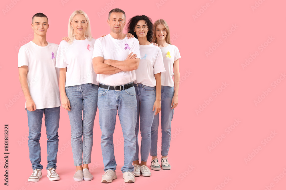 Obraz premium Diverse group of people wearing awareness ribbons for support and solidarity on pink background