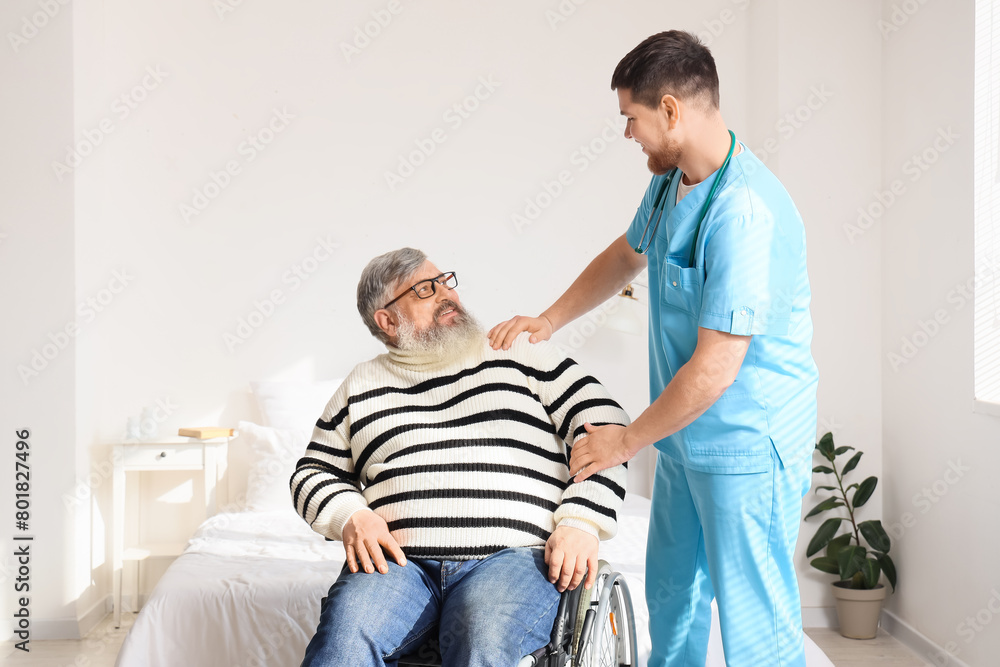 Obraz premium Senior man in wheelchair with caregiver smiling at home