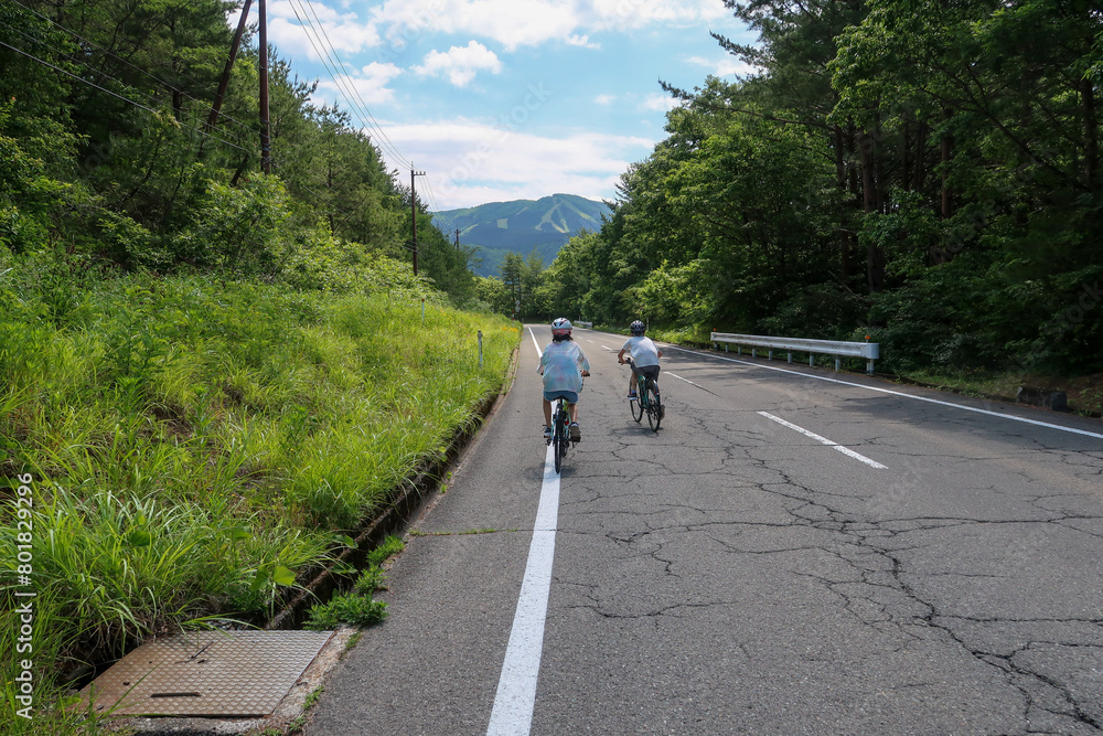 夏の山道を自転車で登る子供 夏の山道を自転車で登る子供